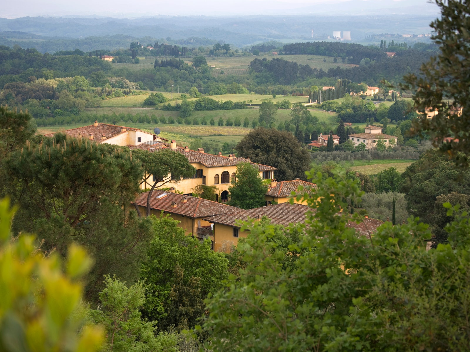 Celebrity Wineries yellow building with green hills winery in italy owned by Sting