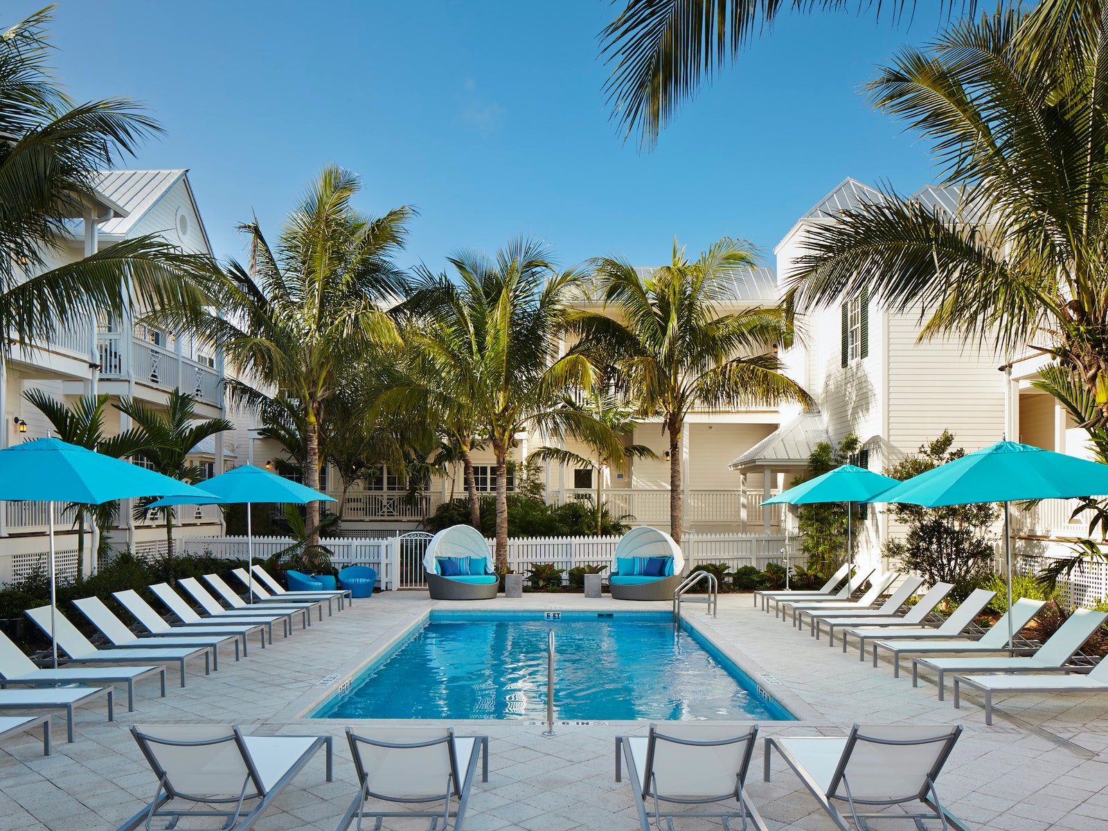 a hotel pool with chaises around it