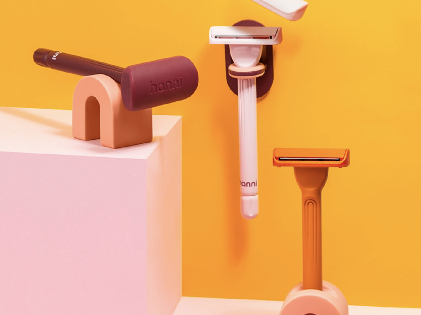 three colorful razors on stands
